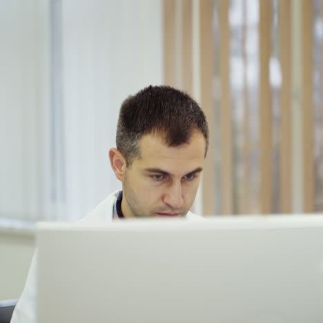 confident doctor sitting at his desk with computer. doctor in his office