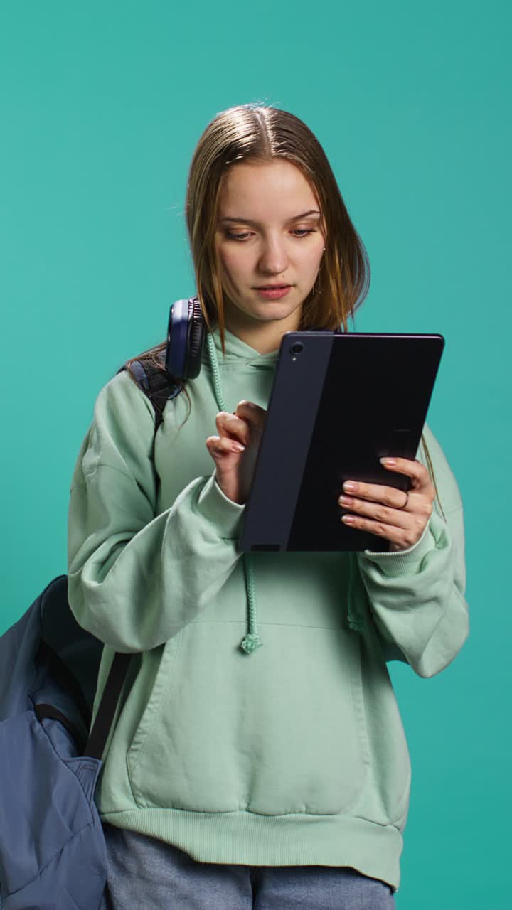 Video verticale. Donna che scorre sul touchscreen di un tablet, controllando il feed dei social media