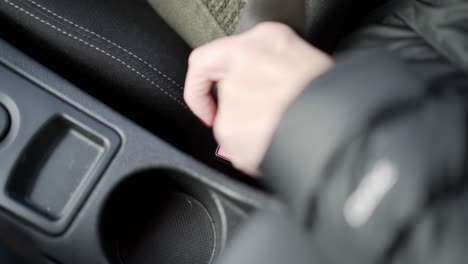 Car-seat-belt-being-clicked-in-place-by-woman-hand