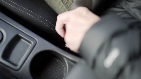 el cinturón de seguridad del coche se coloca en su lugar con la mano de una mujer