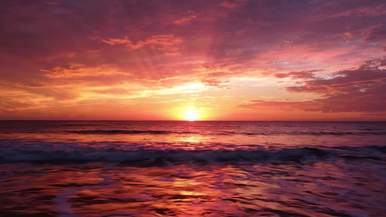 A Breathtaking Sunset Over the Ocean Waves: Witness the Vibrant Colors and Tranquil Beauty of Nature as Day Transitions into Night