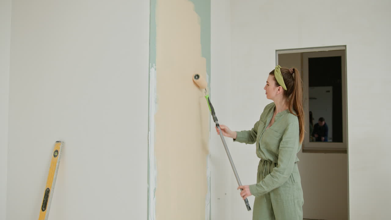 Una mujer pintando una pared.