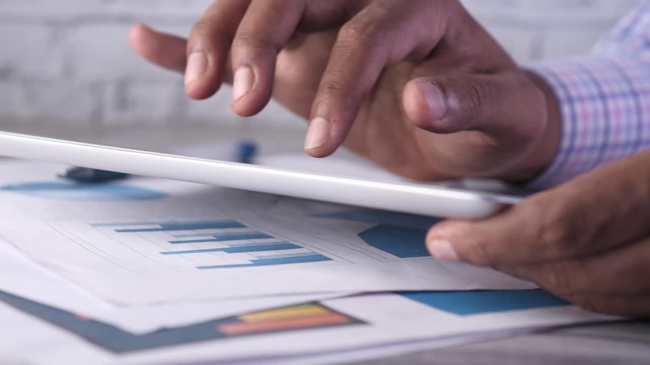 persona que utiliza una tableta con documentos financieros