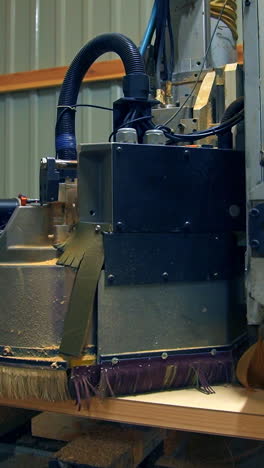 polishing the wooden part of the future door. automatic tool machine moves over the surface of timber plank. vertical video