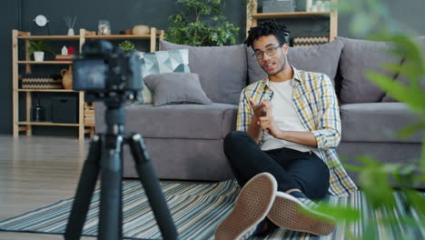 young man recording a video blog at home