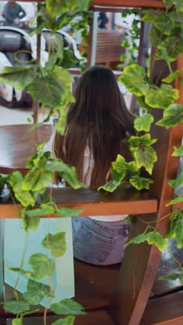 장식 된 나무 좌석에 앉아있는 멋진 젊은 여성, 에 쇼핑 가방을 들고, 쇼핑몰의 활기찬, 활기찬 분위기의 비는 배경에서 움직이는 사람들과 함께
