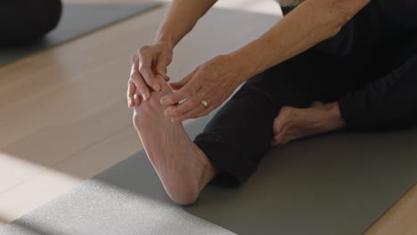 yoga class beautiful old woman exercising healthy meditation practice head to knee forward bend pose enjoying group physical fitness workout in studio