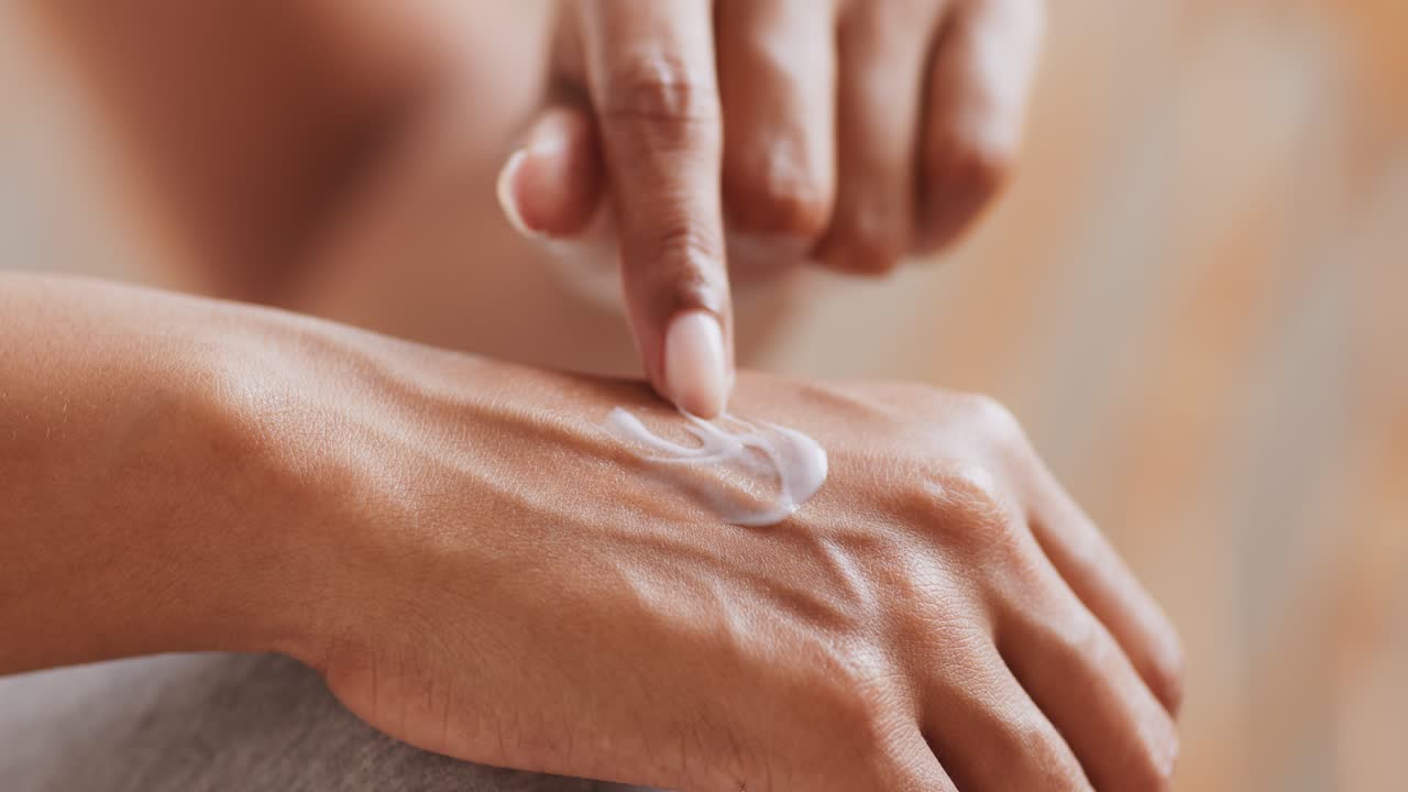 mulher a aplicar creme à mão