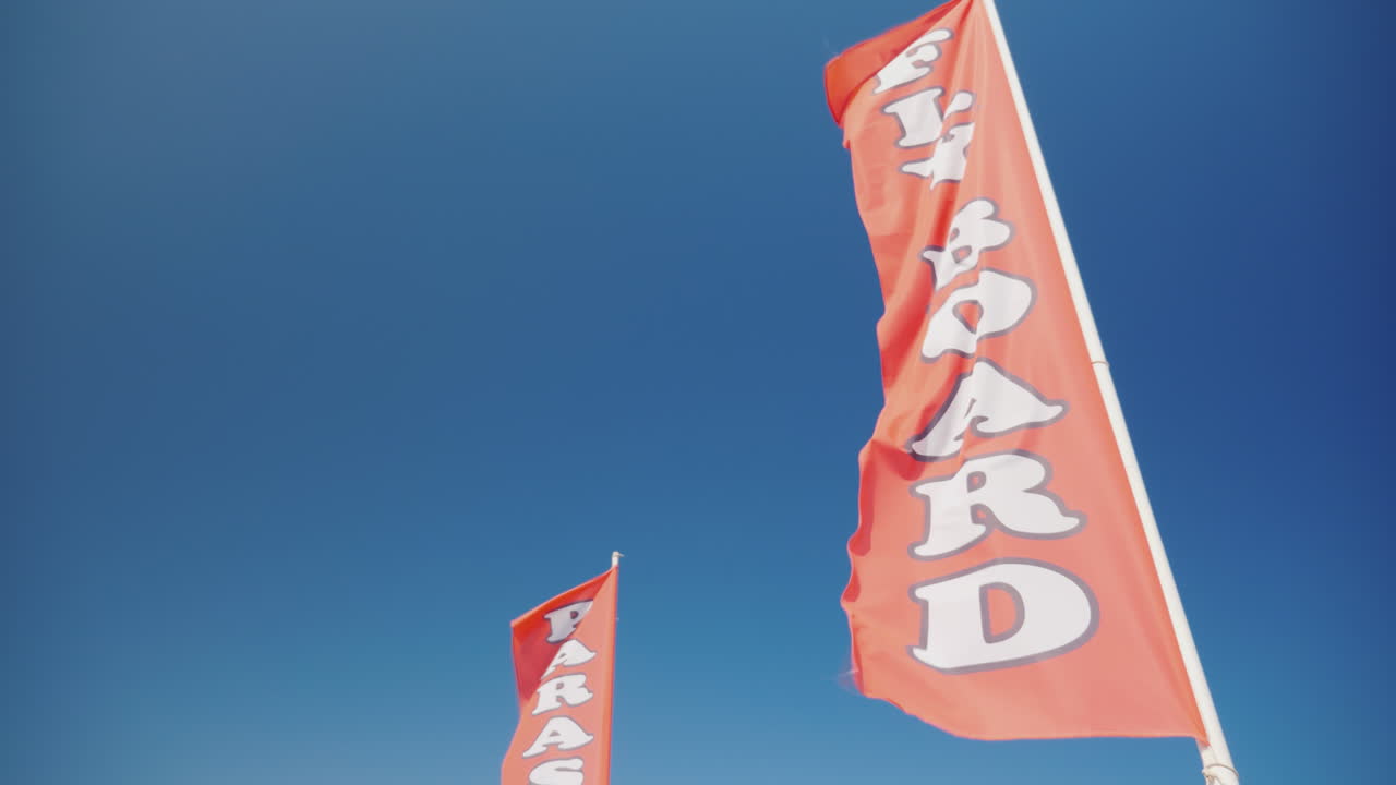 bandera roja con una inscripción fly board publicidad de deportes acuáticos en la playa 4k video