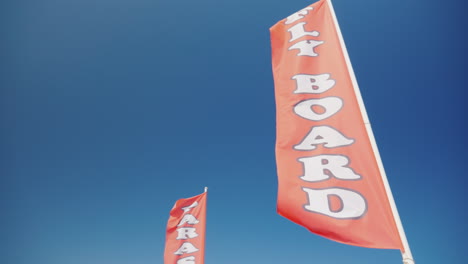 red flag with an inscription fly board advertising of water sports on the beach 4k video