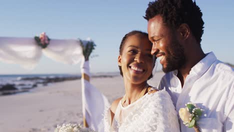 african american couple in love getting married and smiling on the beach
