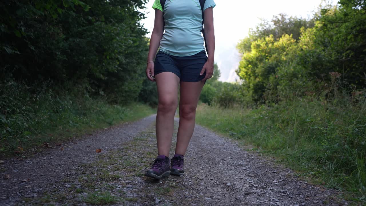 Donna che cammina su un sentiero di ghiaia nella natura