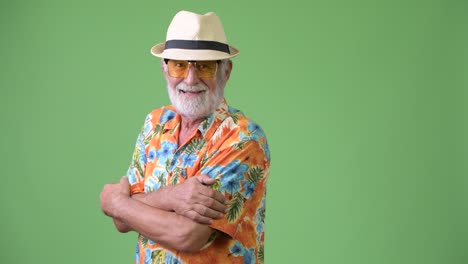 hombre turista barbudo y guapo listo para las vacaciones contra un fondo verde