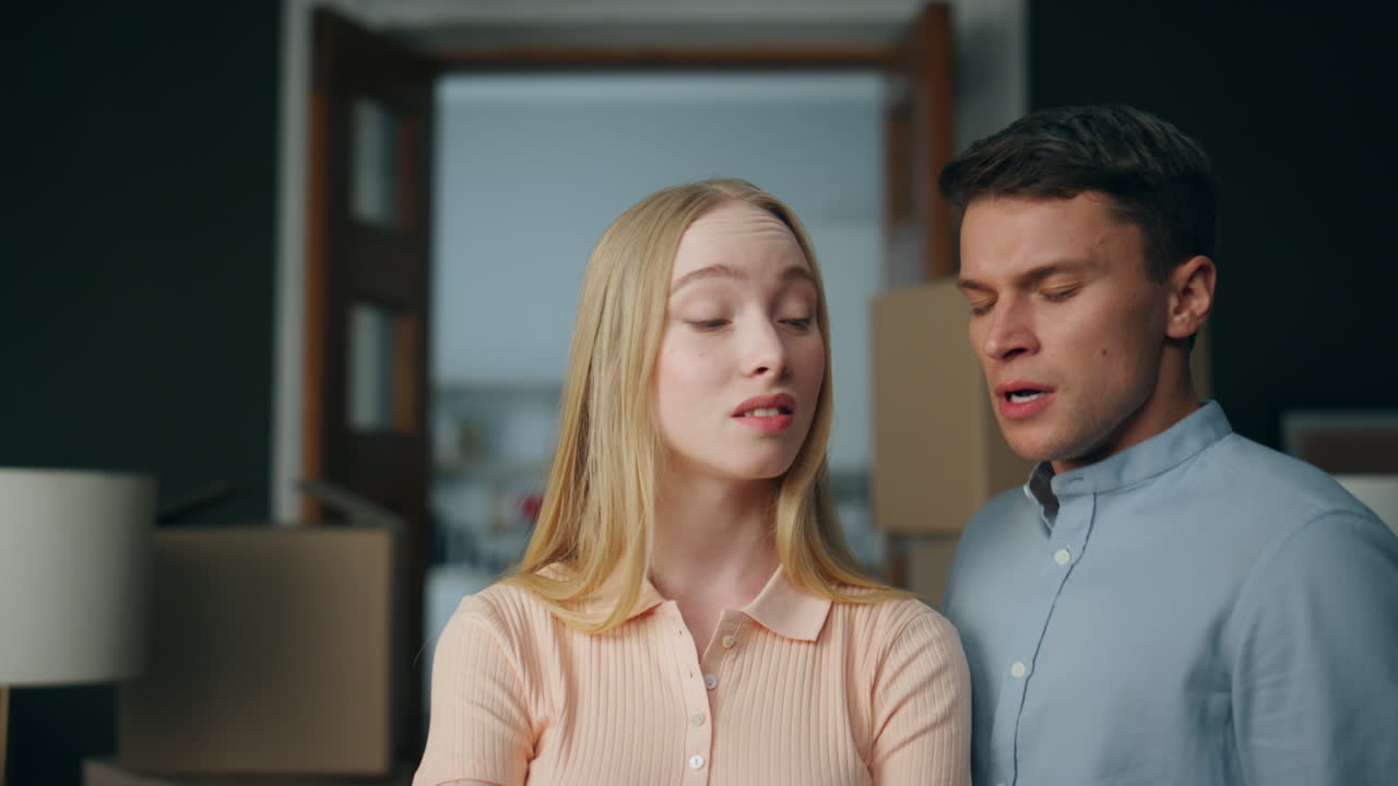 Abusive man scolding woman in new home close up. Young unhappy couple arguing.