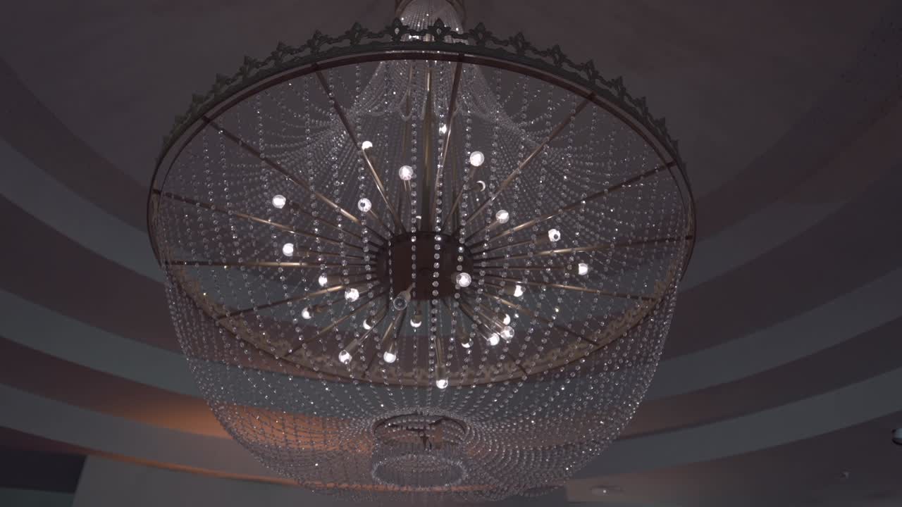 grand, intricate crystal chandelier illuminated elegantly, adding a luxurious ambiance