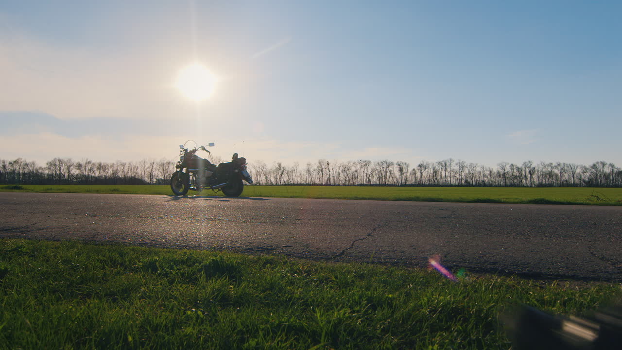 오토바이에 헬멧을 들고 태양을 바라보는 바이커