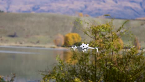 a drone navigates through a picturesque new zealand landscape with mountains and autumn foliage, captured in smooth motion