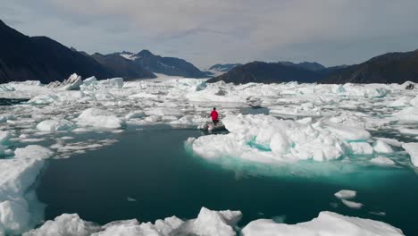 Luftaufnahme-Eines-Mannes-Im-Motorboot,-Der-Zwischen-Eisbergen-An-Der-Küste-Alaskas-Segelt
