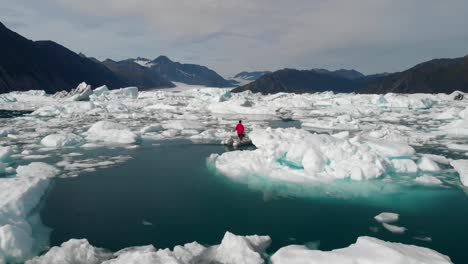 vista aérea del hombre en lancha navegando entre icebergs por la costa de alaska