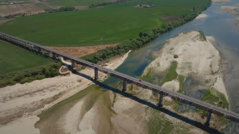 río seco en verano sobre un puente con toma aérea de campos agrícolas