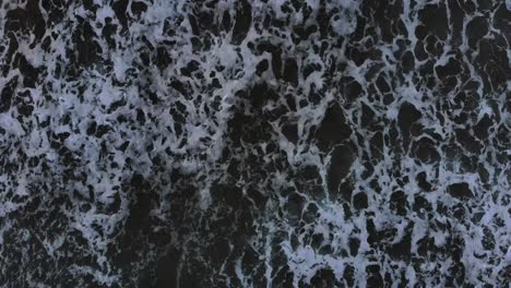 vista aérea de arriba hacia abajo de las olas del océano rompiendo