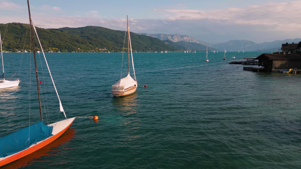 Attersee lake in Austria with sailing ship boat, clear blue water and alps mountains near idyllic scenic Wolfgangsee, Mondsee close to famous Mozart city Salzburg