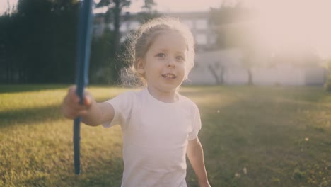 girl in t-shirt with butterfly net runs along spring park