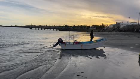 flat bottom motorboat is dragged ashore by suv and fishermen