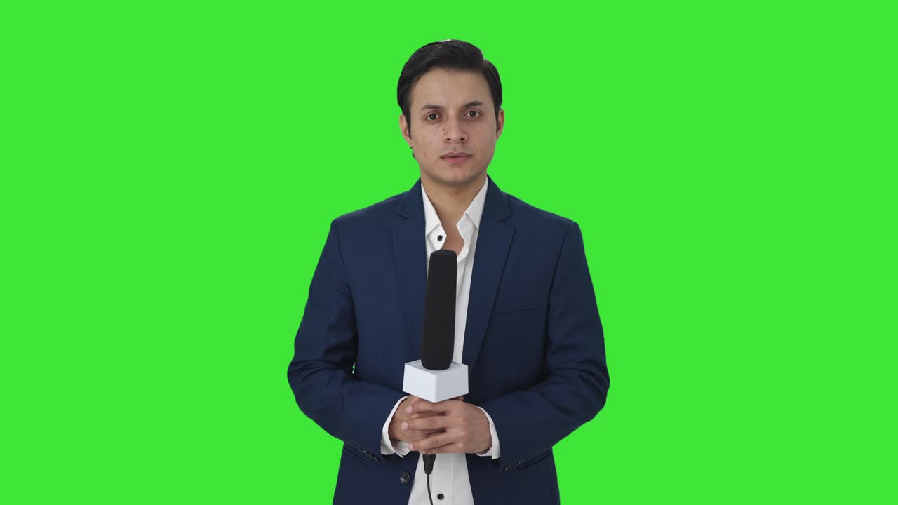 Portrait of Confident Indian reporter Green screen