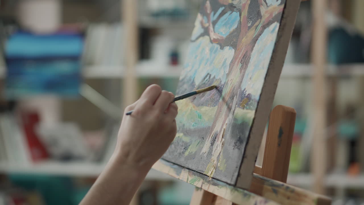 persona pintando una imagen de un árbol en lienzo