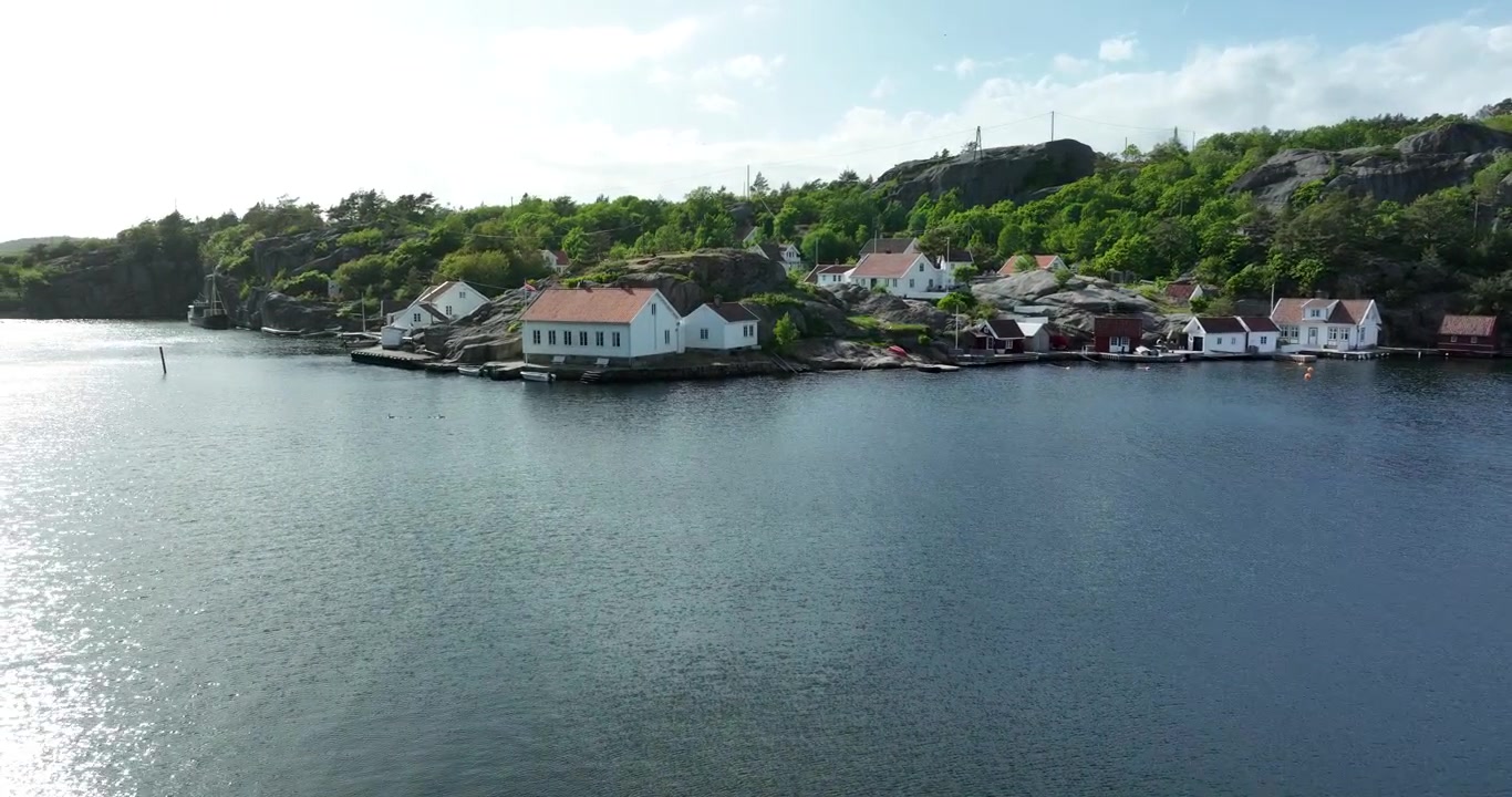 Naturskjønt kystlandskap med steinete klipper og havnelandsby ved Ny Hellesund, Norge