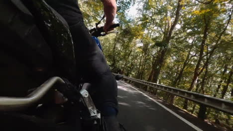 el hombre conduce una motocicleta a través del área del bosque