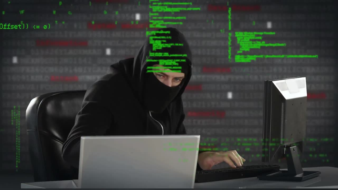 hacker escribiendo en dos computadoras