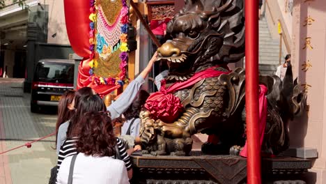 people engaging with dragon statue at temple