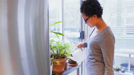 Woman-watering-the-plants-in-the-balcony-4k