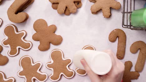 decorating gingerbread cookies with royal icing for christmas.