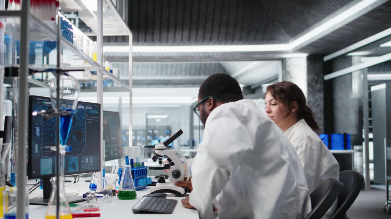 Vertical video Senior researcher records observations from coworkers using microscope