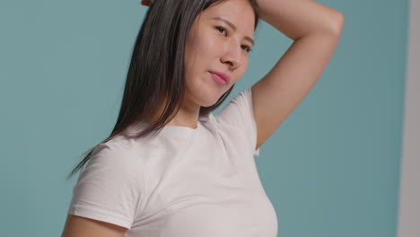 Young-Woman-In-Front-Of-Blue-Studio-Background-Posing-For-Photo-Booth-Style-Portraits-1