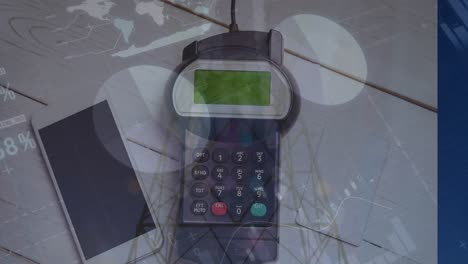 Animation-of-graphs-over-hand-of-caucasian-man-holding-payment-terminal