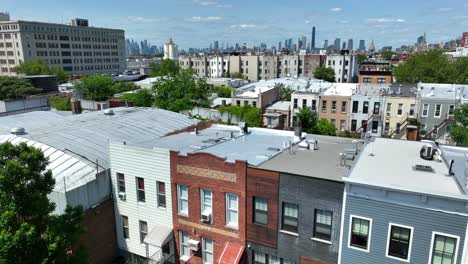 Toma-Aérea-Ascendente-Del-Vecindario-En-El-Distrito-De-Brookyln-Con-La-Ciudad-Industrial-Y-El-Horizonte-De-Nyc-En-El-Fondo---Estableciendo-Una-Vista-Panorámica-De-Drones