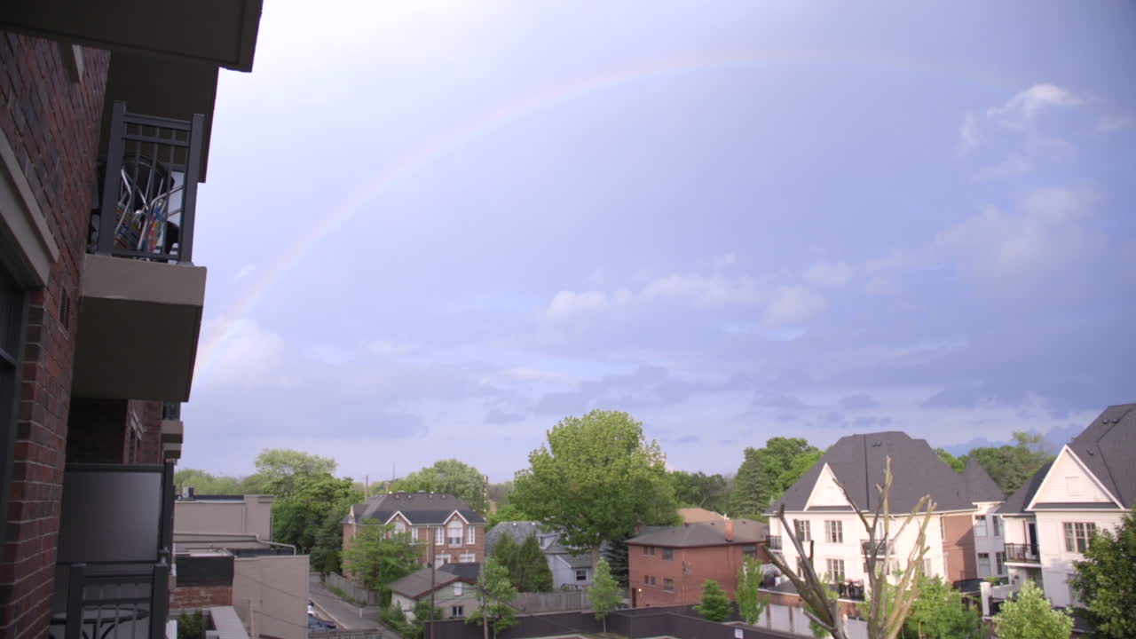 A rainbow appears over a neighbourhood after a storm