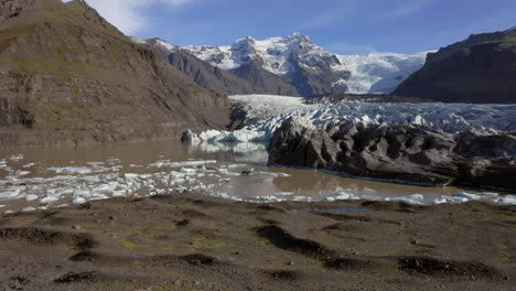 Antena:-Pasando-Por-Un-Hombre-De-Pie-Sobre-Una-Colina-Cerca-Del-Glaciar-Svinafellsjokull-Durante-Un-Día-Soleado