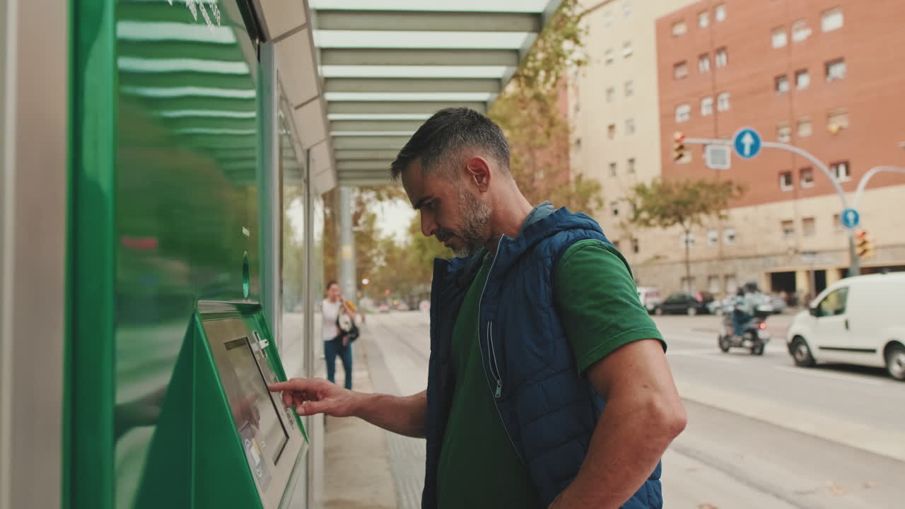 Uomo che usa una biglietteria automatica in una strada cittadina