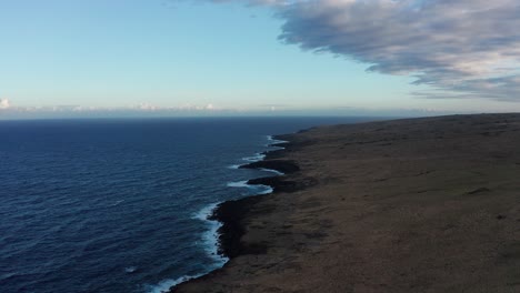 wide descending aerial shot of an ancient lava flow from nearby mauna loa on the southern coast of the big island of hawai'i