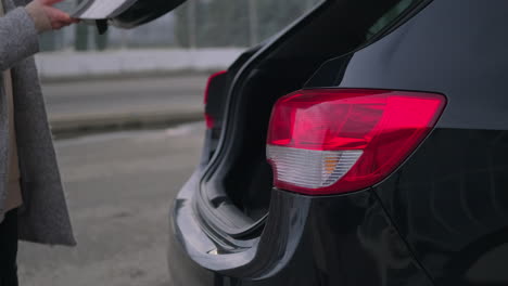 woman opening car trunk