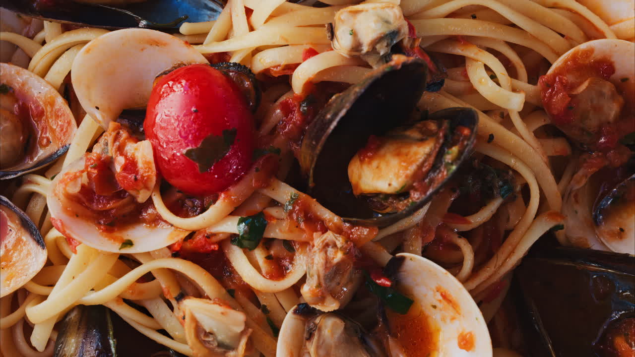 Primo piano di un piatto di pasta con frutti di mare e salsa di pomodoro in un ristorante