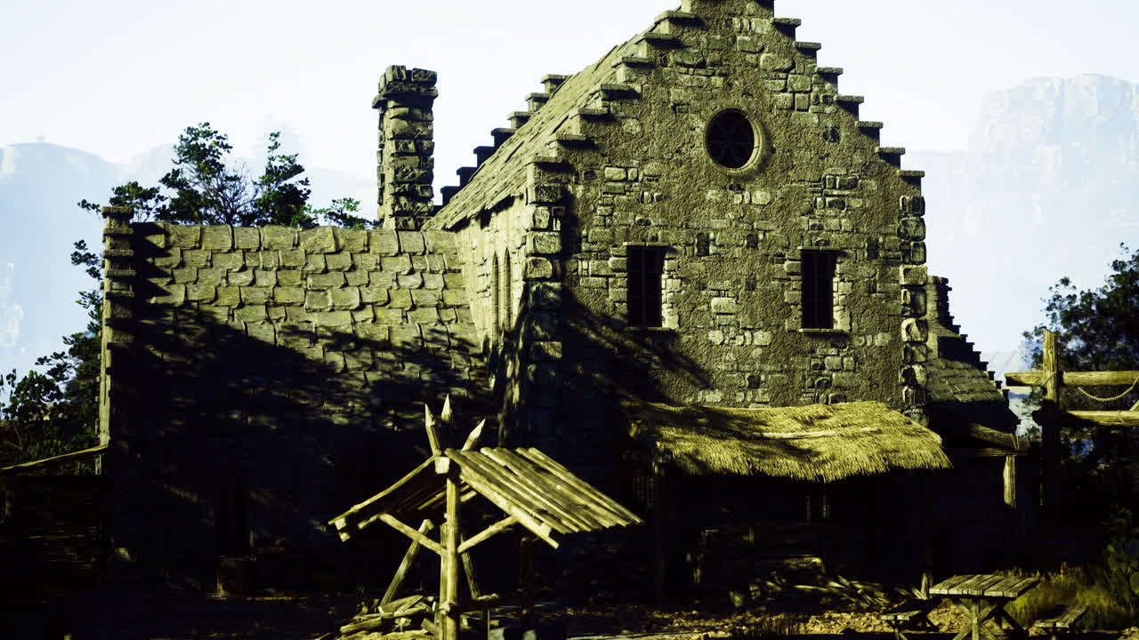 Historic stone building with thatched roof surrounded by trees at noon