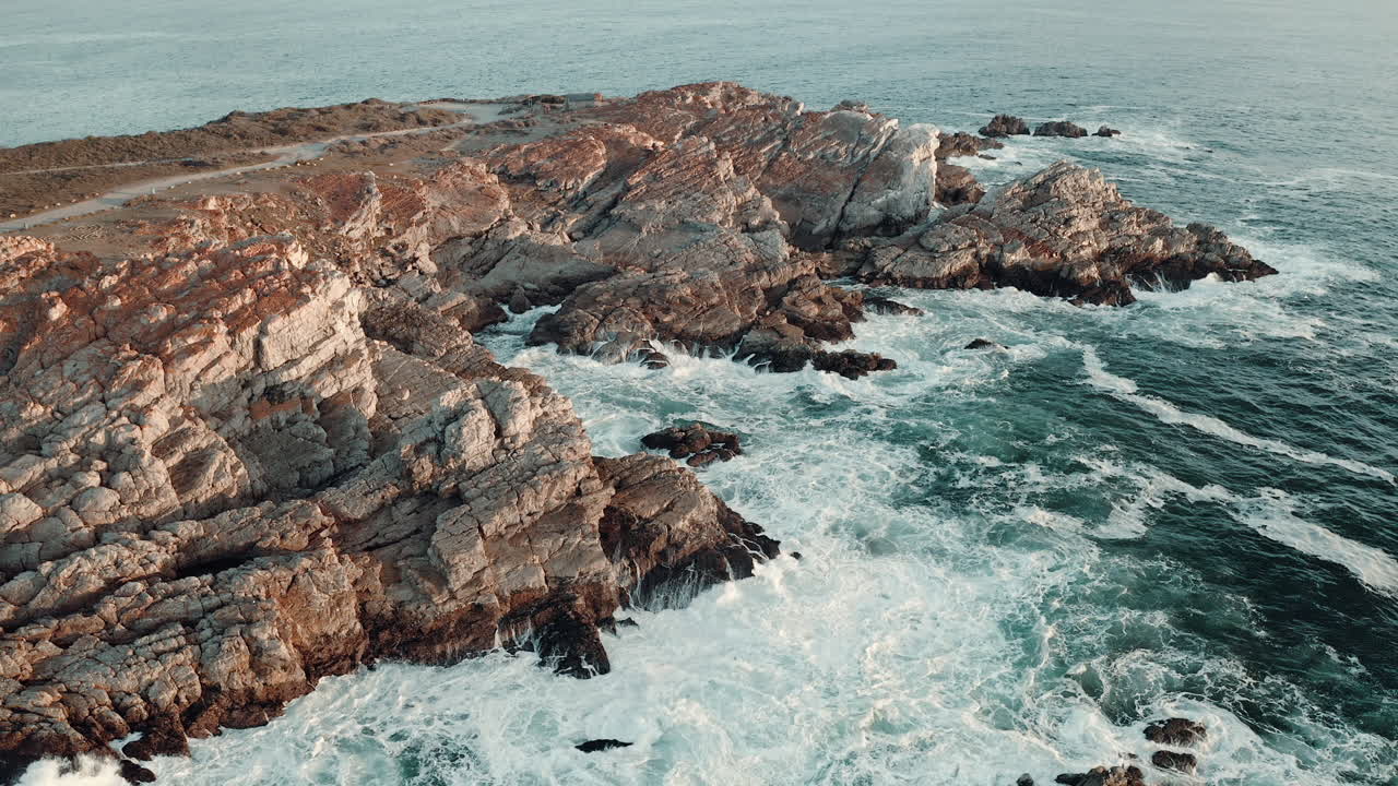 Onde marine spumeggianti che si infrangono sulla costa rocciosa durante l'estate a Vleesbaai, Capo Occidentale, Sudafrica - Ripresa aerea con drone