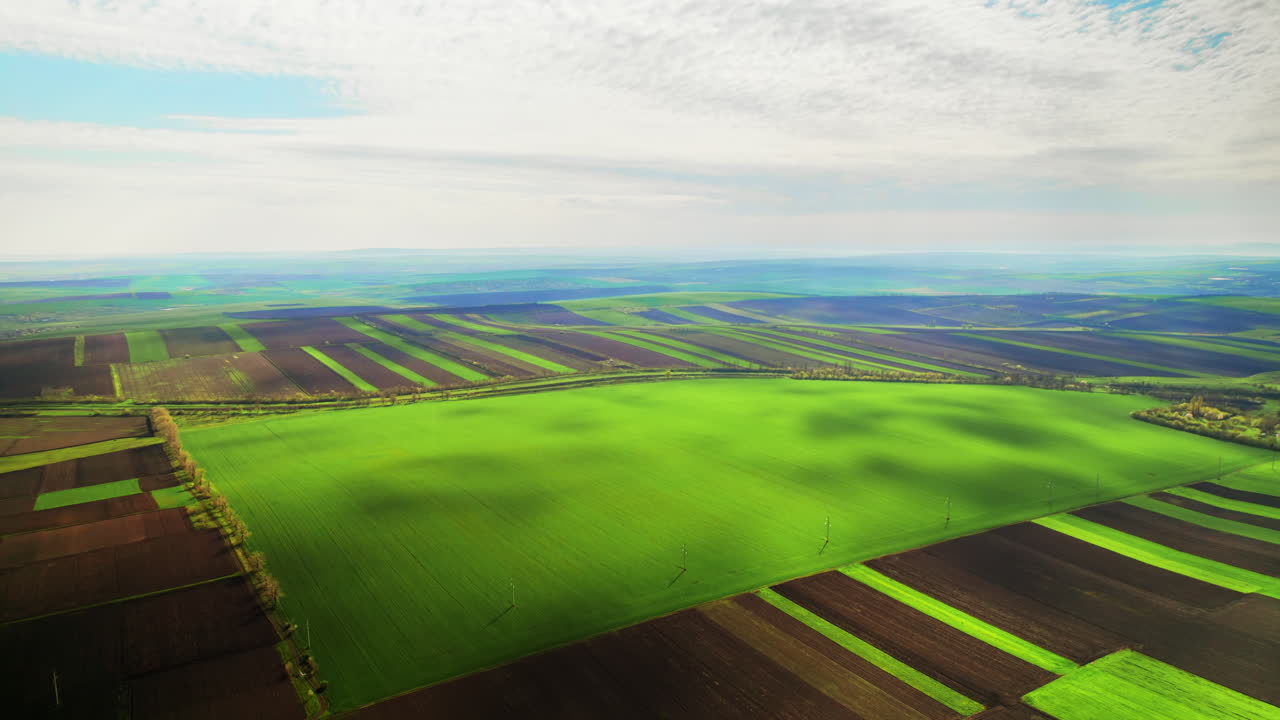 Vista aérea con dron de la naturaleza en Moldavia. Amplios campos verdes y arados, cielo nuboso