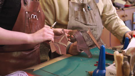 apprentice in bespoke shoemaker glueing together leather